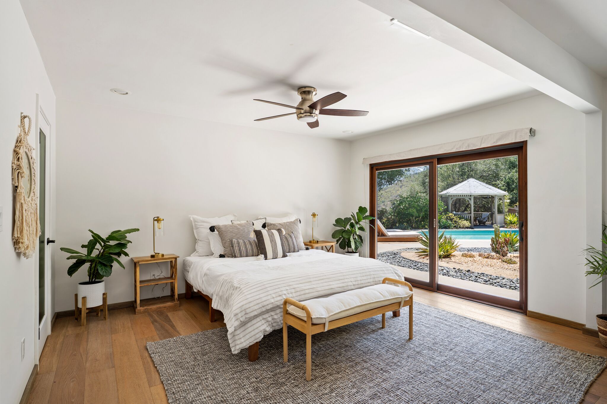 Bedroom with white bedding and sliding doors opening to the gardens