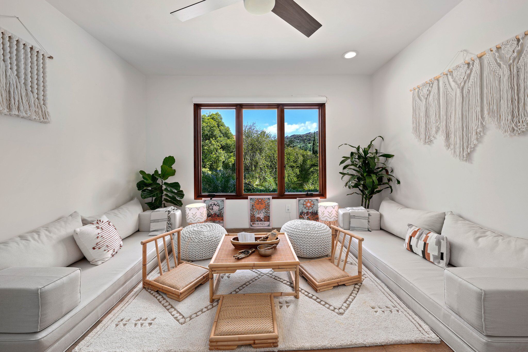 White meditation lounge with macrame wall hangings and canyon window