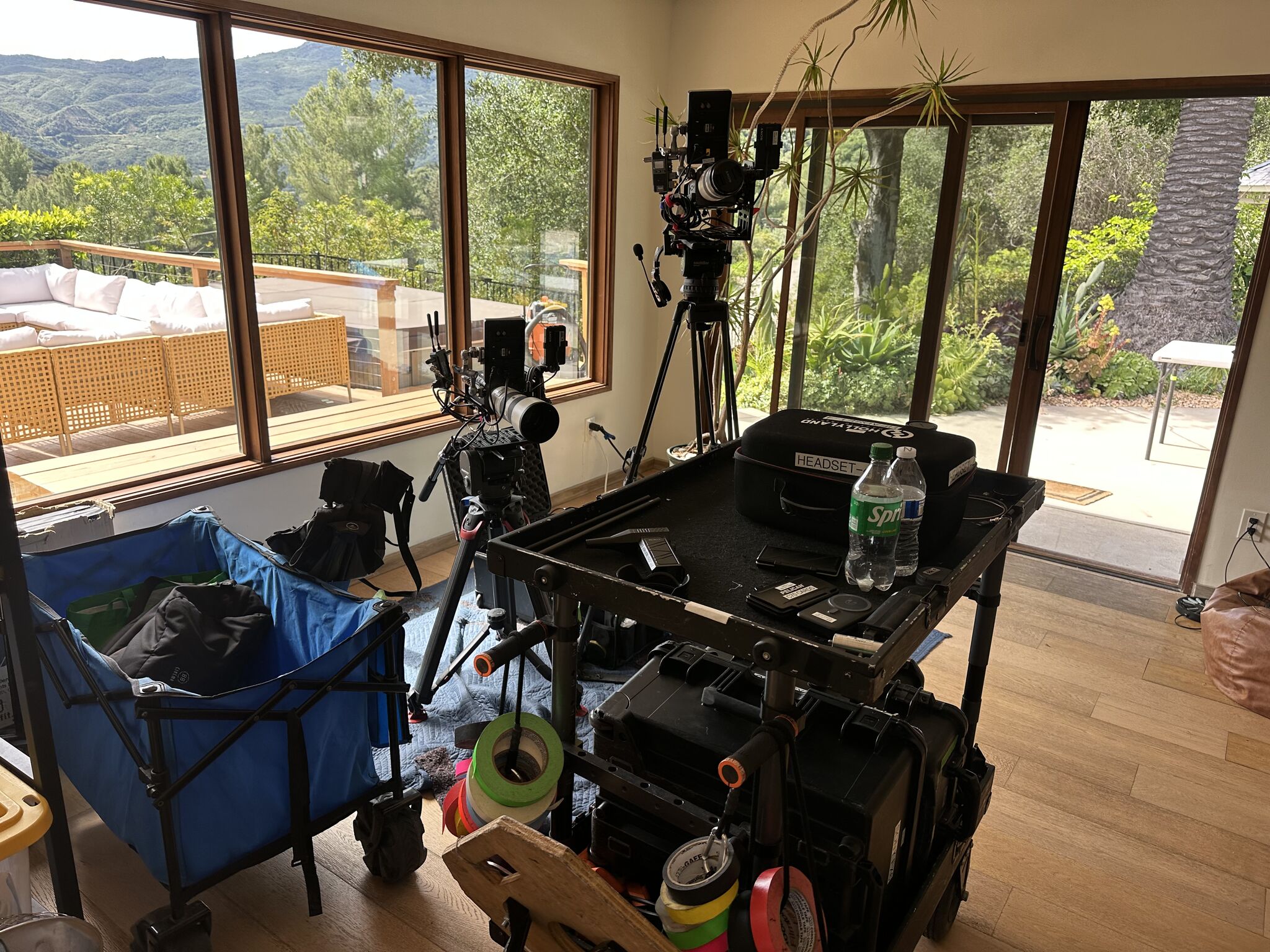Cinema camera rig and production carts in the great room with canyon views through the windows