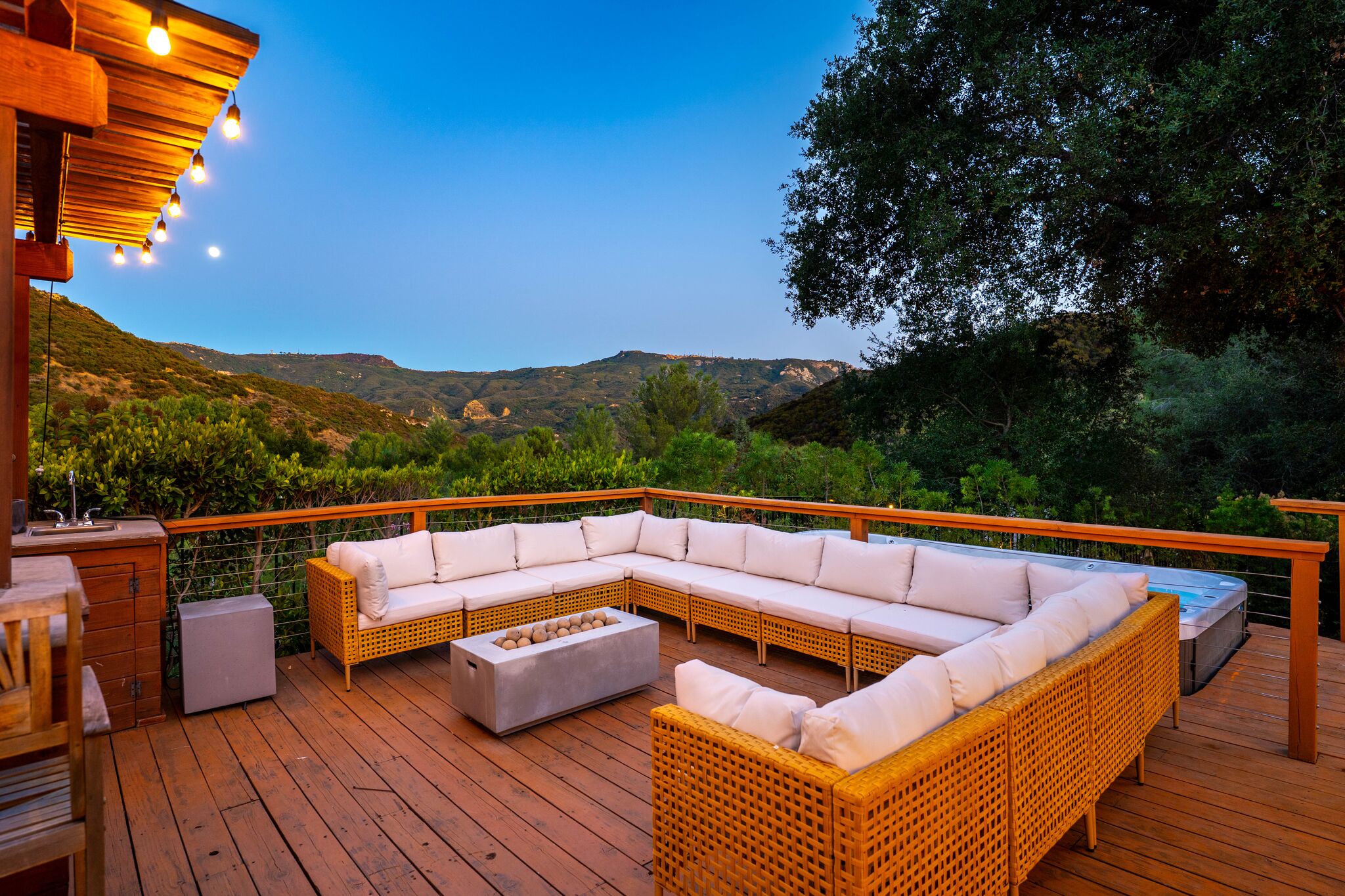 White sectional on the spa deck at dusk with the moon rising over the canyon